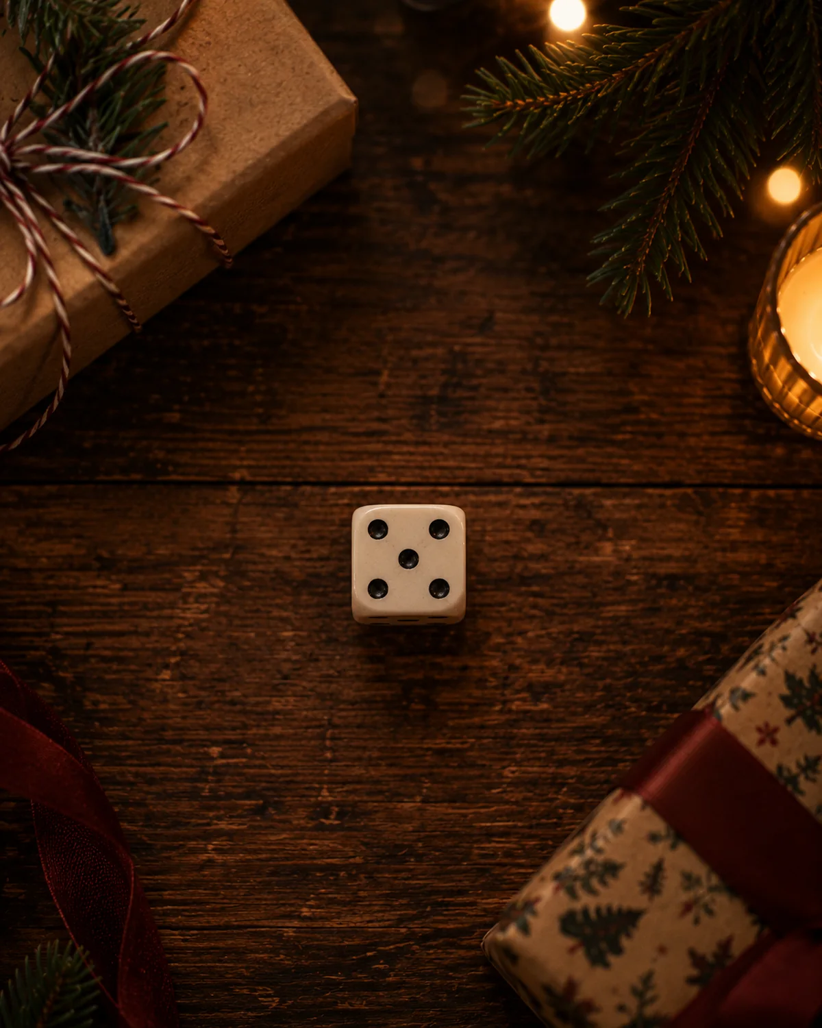 Tärning och inslagna paket på ett julpyntat bord före julklappsspelet.